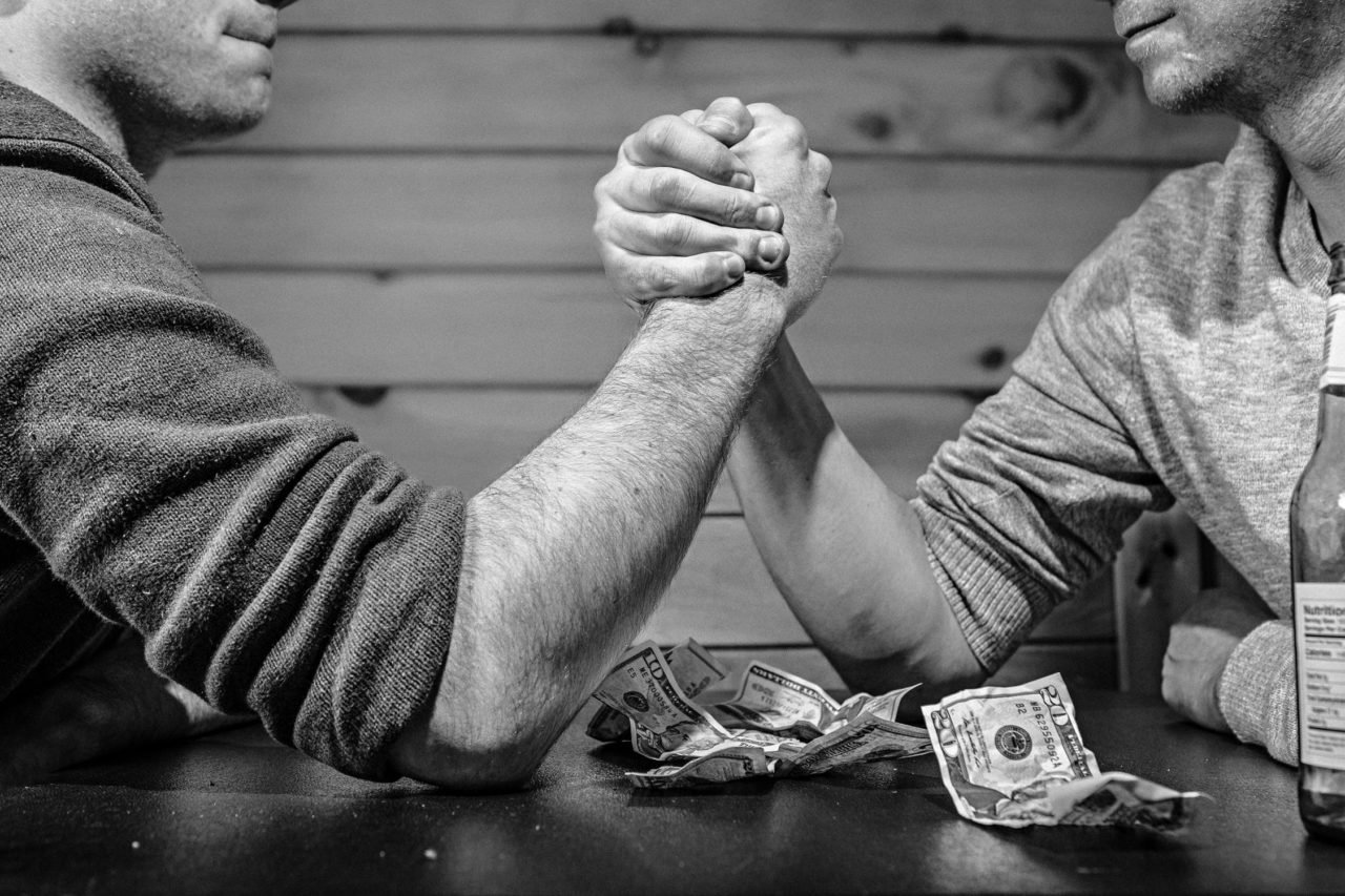 two guys arm wrestling at a bar in black and white